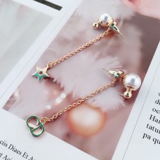 Pendientes colgantes asimétricos de oro amarillo y perla blanca con detalle de estrella CD Signature de Dior La Petite Tribale